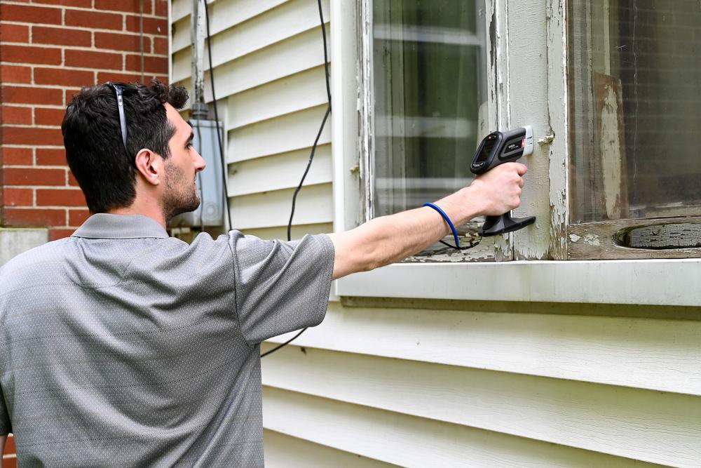 Chautauqua County Health Department staff conducting a lead test on an old windowpane.